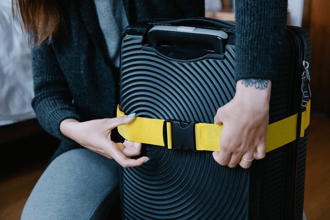 Free A Person Checking the Strap on Luggage Stock Photo
