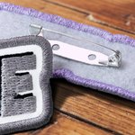 Gepersonaliseerde retro broche met levendig borduurwerk, kleurrijke contourletters en naam – DIY-naaicadeau voor vrienden en knutselfanaten