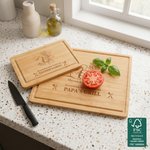 Planche à découper personnalisée « Dad's Grill » en bambou certifié FSC, gravée d'un « fist bump » et des prénoms, fabriquée aux États-Unis. Cadeau pour la fête des Pères, une pendaison de crémaillère