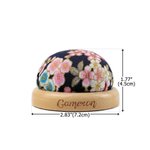 Personlig, färgglad nåldyna i vintagestil med blommönster, graverat namn och träfot – ett sömnadshantverk som födelsedagspresent till skräddare och hantverkare