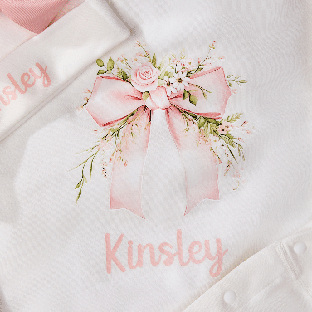 Spersonalizowany, wykonany w 100% z bawełny, miękki kombinezon dla dziewczynki z motywem kwiatowym i kokardką oraz czapeczką z imieniem – prezent na baby shower i urodziny dla noworodka oraz świeżo up 6