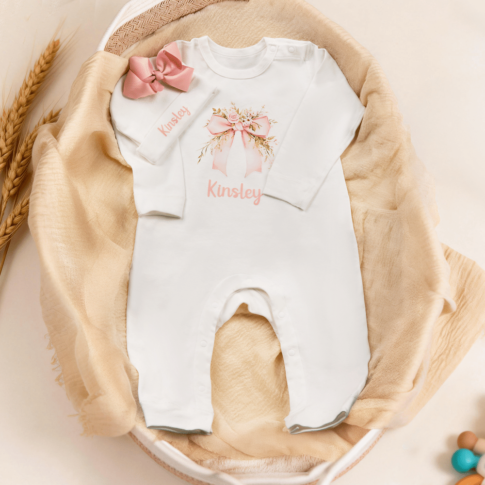 Spersonalizowany, wykonany w 100% z bawełny, miękki kombinezon dla dziewczynki z motywem kwiatowym i kokardką oraz czapeczką z imieniem – prezent na baby shower i urodziny dla noworodka oraz świeżo up 2