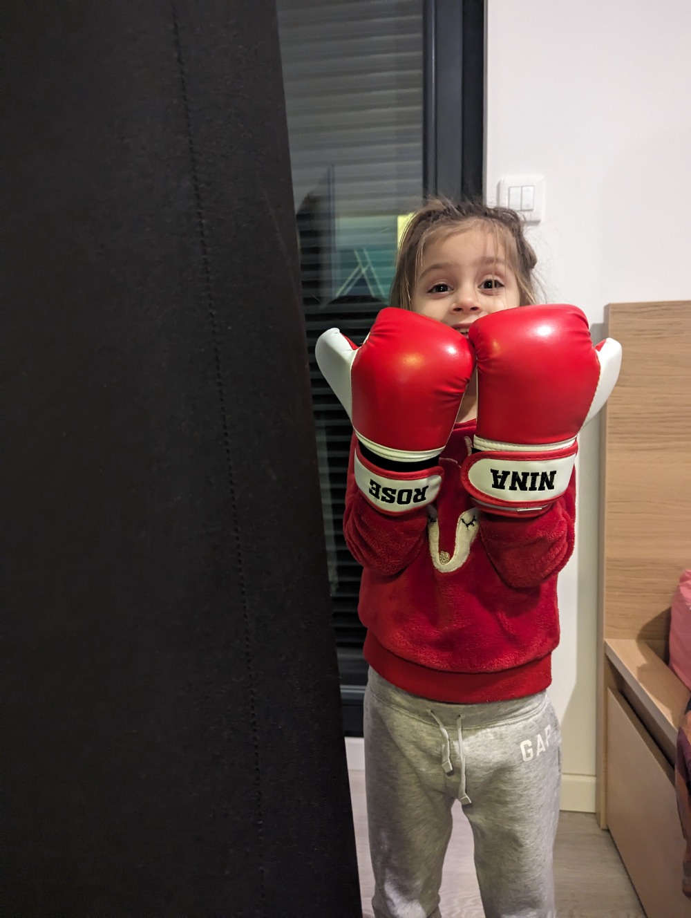une fille avec ses gants de boxe personnalisés avec son nom brodé